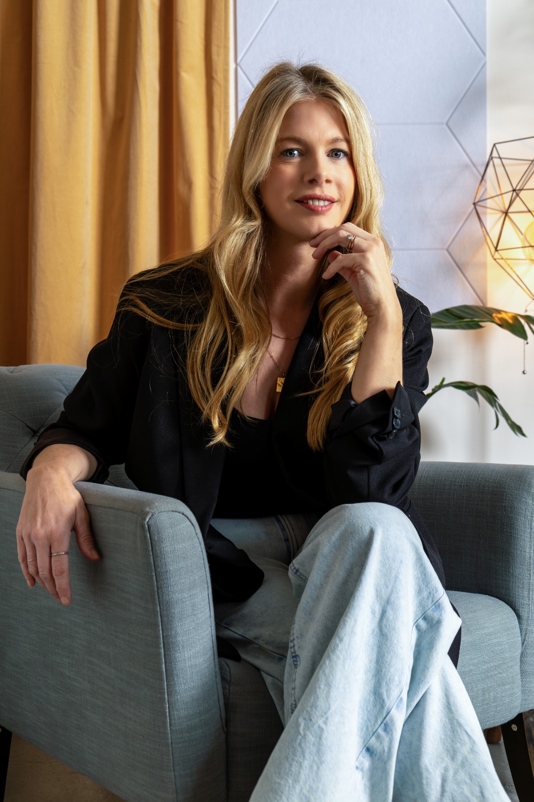 Beth Clay in a black jacket, seated in an armchair
